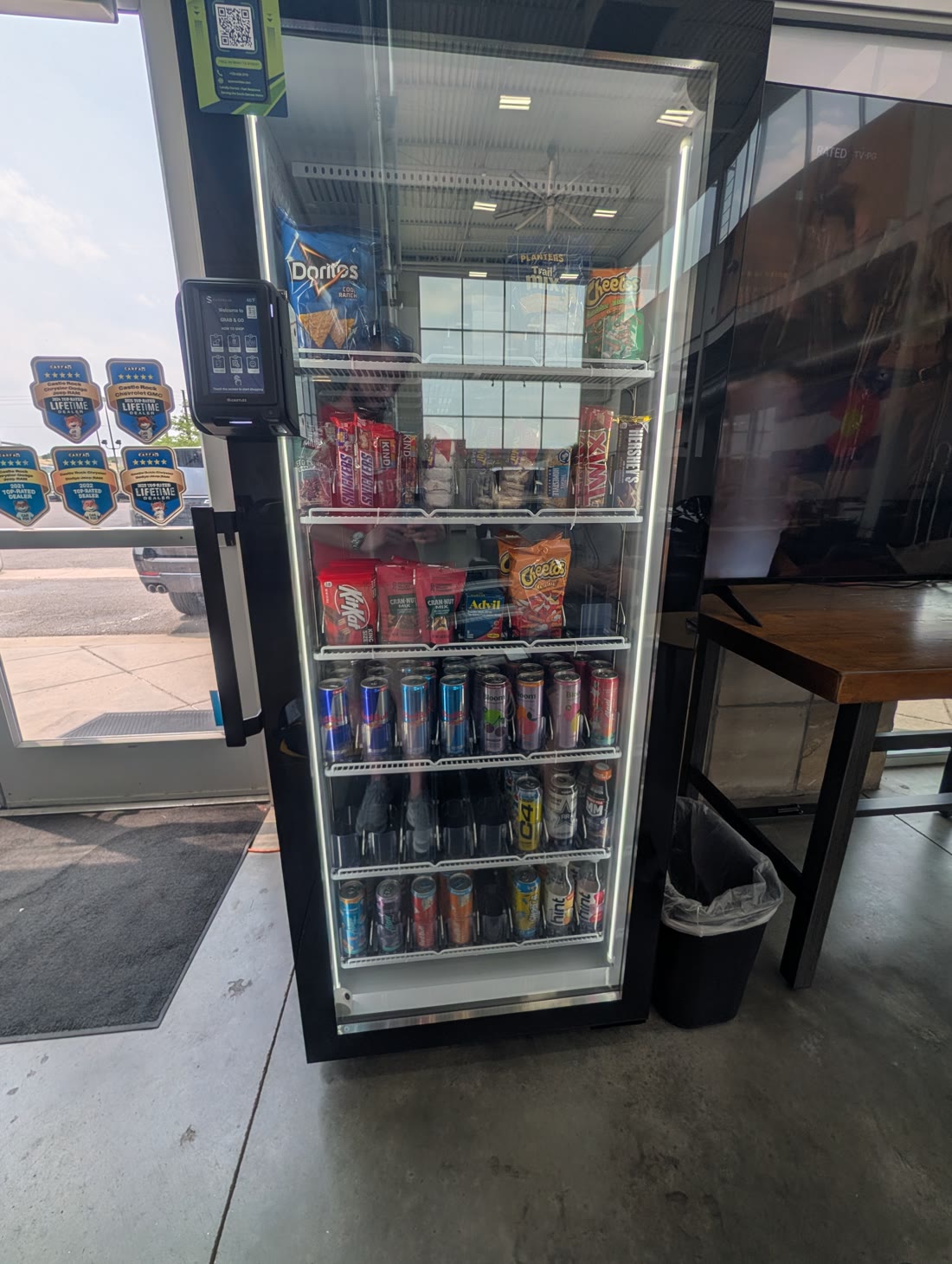 On Point Amenities smart cooler installed in the Castle Rock Autoplex GMC showroom, beside the dealership's Top-Rated Dealer awards