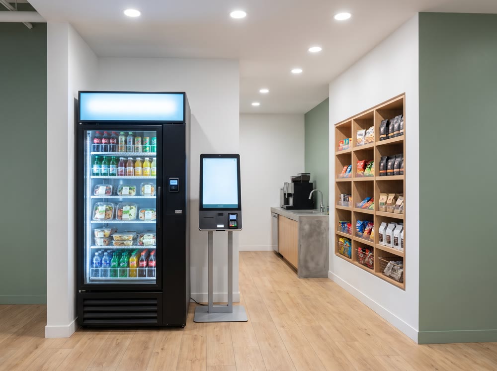 Concept render: full micro market setup with kiosk, cooler, and snack wall in an office
